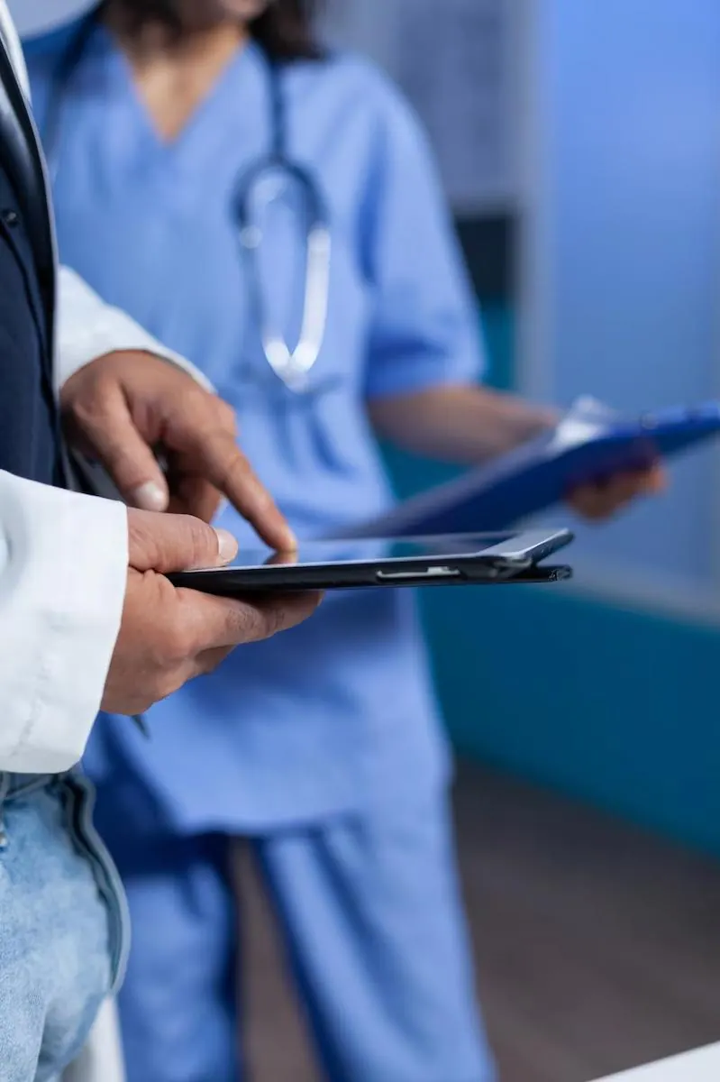 Médico e enfermeira conferindo exames em um tablet no hospital